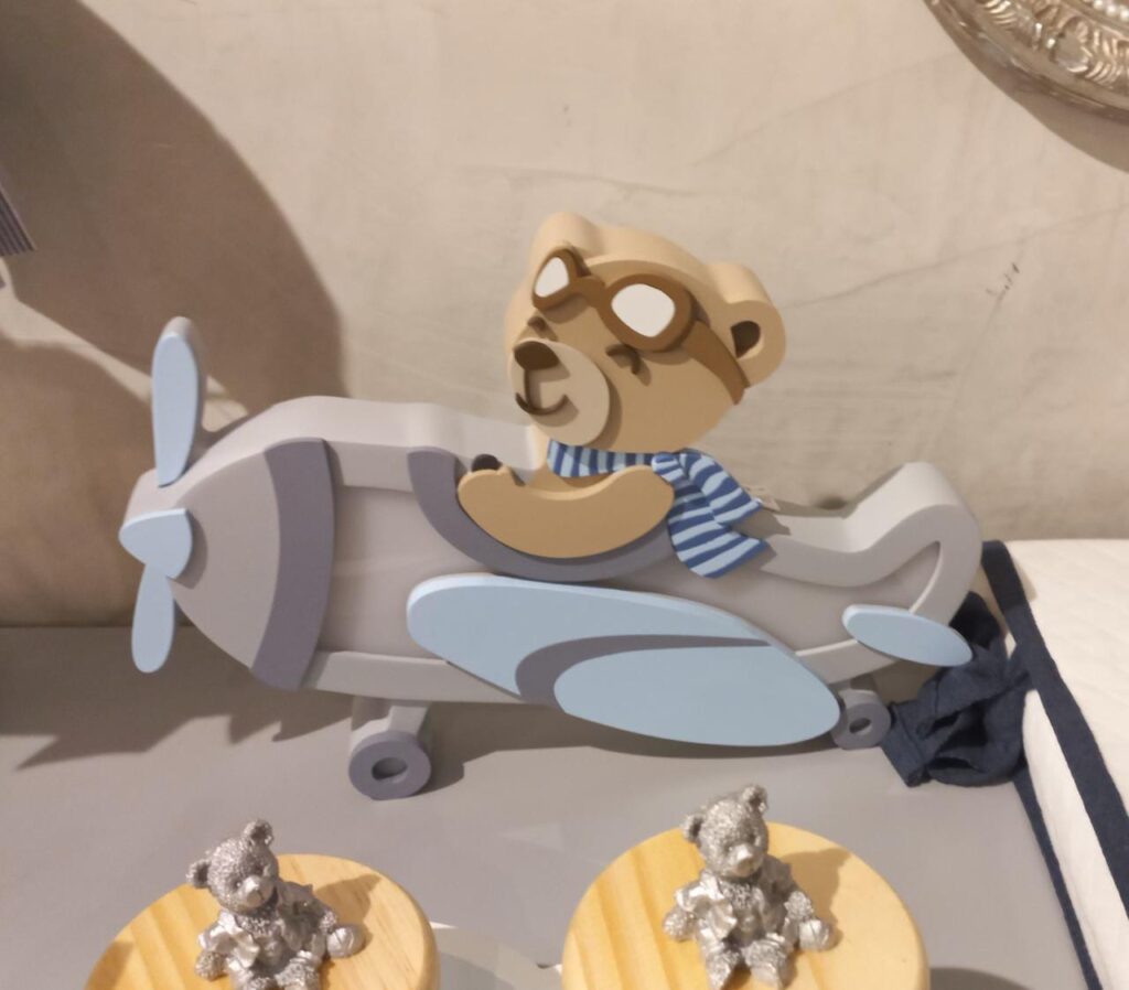 Decoração de quarto de bebê com tema aviador, incluindo aviões, nuvens e cores suaves, criando um ambiente tranquilo e mágico.