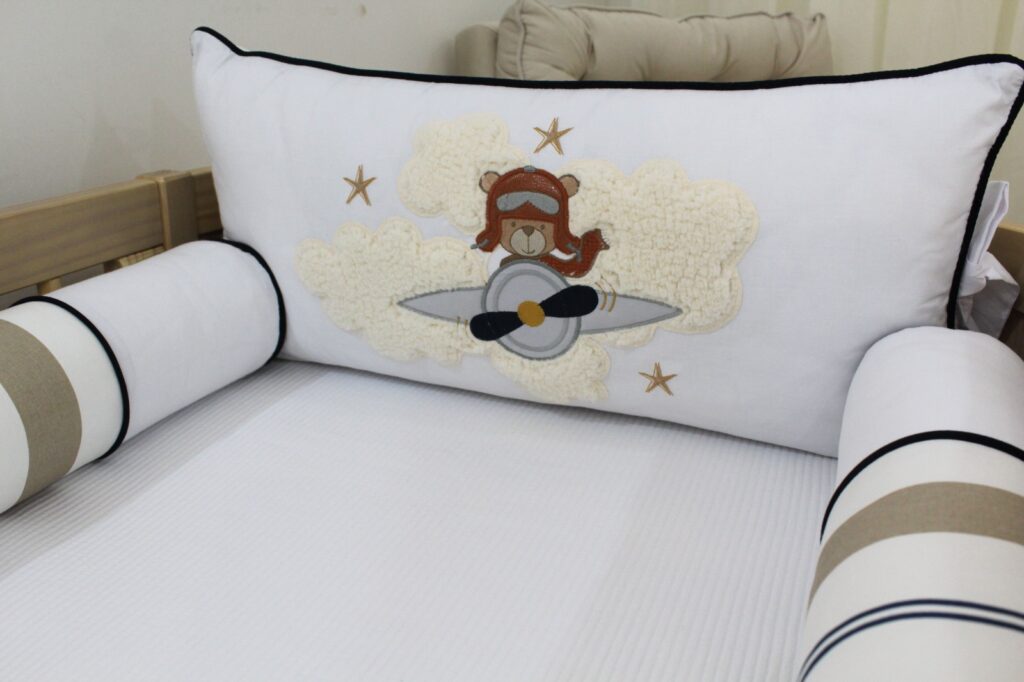 Decoração de quarto de bebê com tema aviador, incluindo aviões, nuvens e cores suaves, criando um ambiente tranquilo e mágico.