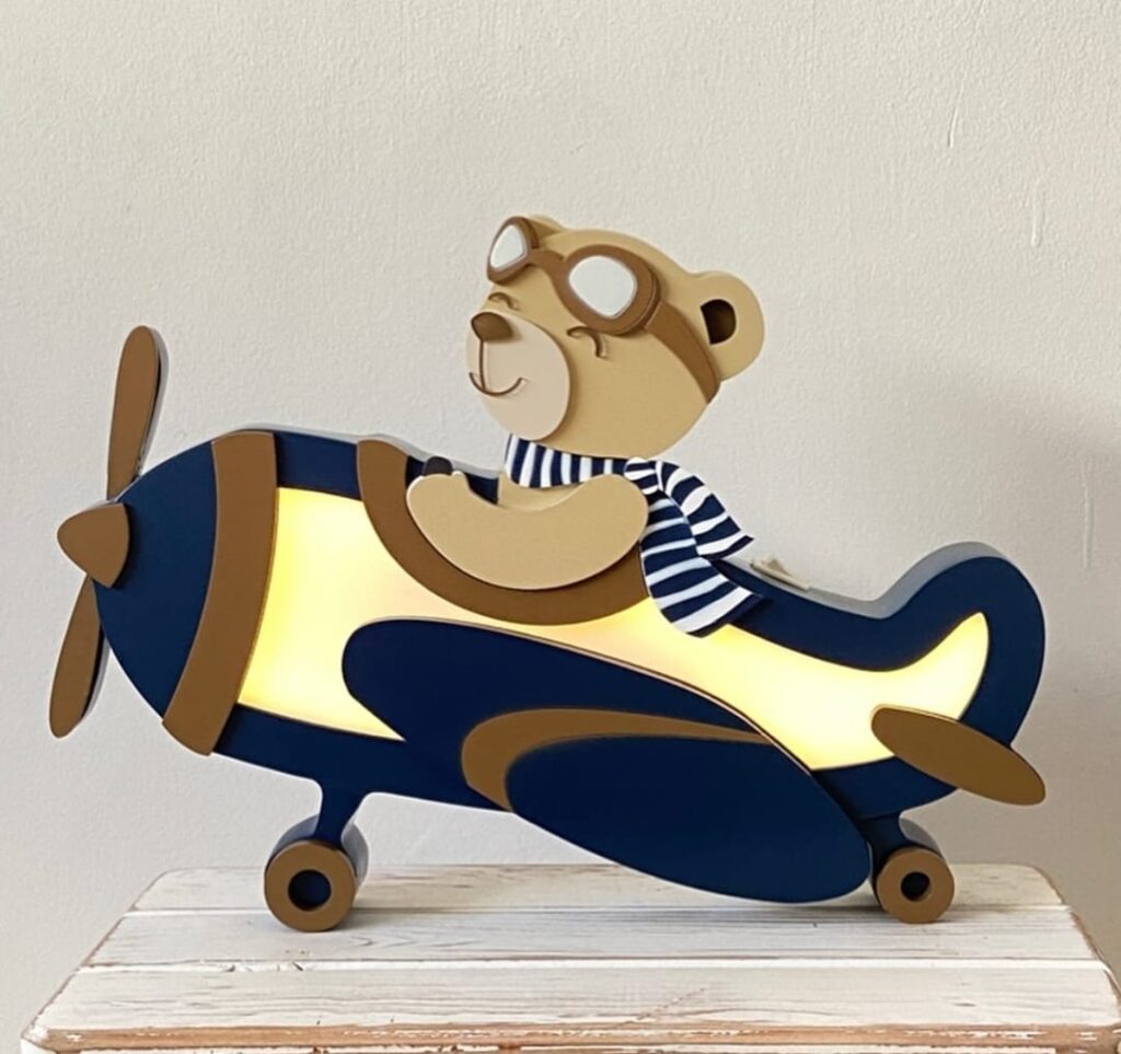 Decoração de quarto de bebê com tema aviador, incluindo aviões, nuvens e cores suaves, criando um ambiente tranquilo e mágico.